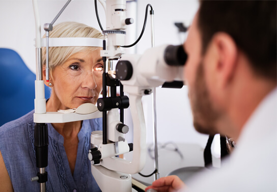 An older woman receiving an eye exam.