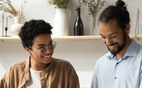 Happy couple wearing glasses in a kitchen.